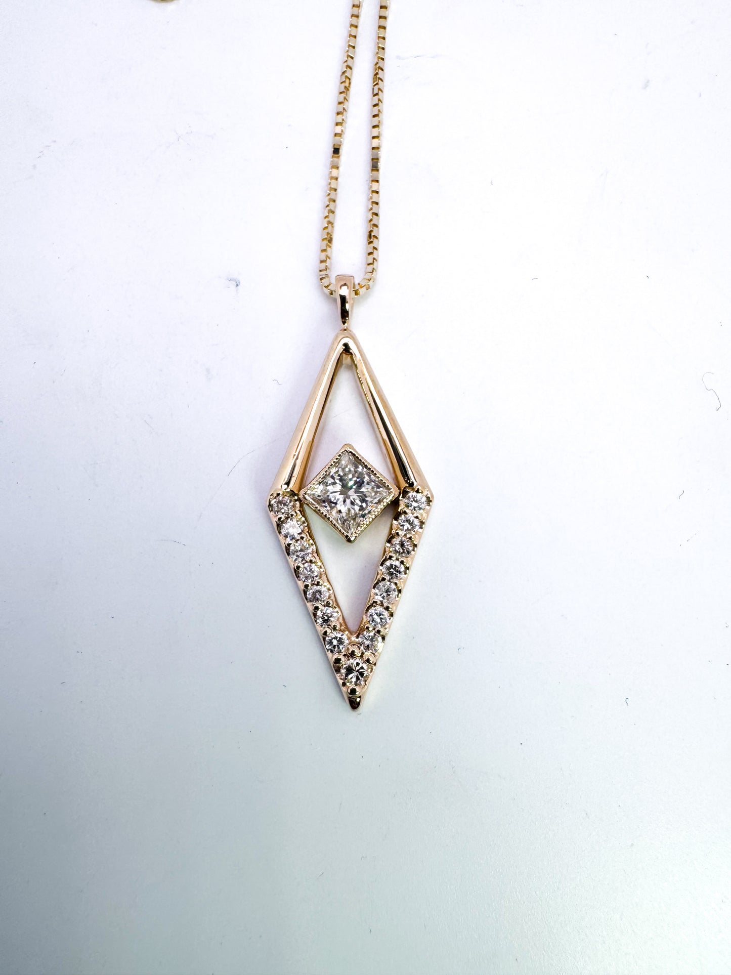 14k, yellow gold, custom diamond pendant .52 natura princess cut setl kite shaped diamond set with .30 carats of side diamonds.