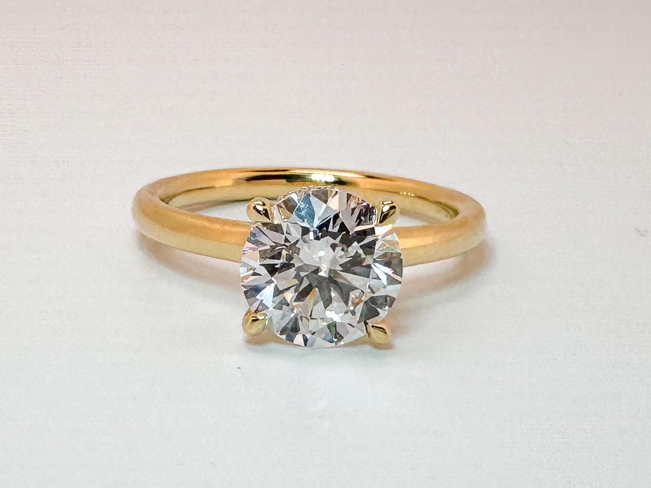 14K, Yellow gold, 2.06 lab grown round brilliant, set with .04 carats of side diamond. IGI CERTIFIED VS1 E