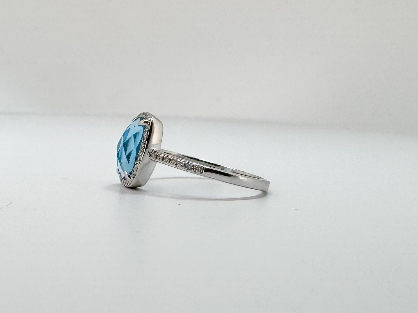 14K, White gold, 2.10 carat checker board cut, blue topaz, set with .14 carats of side diamonds.