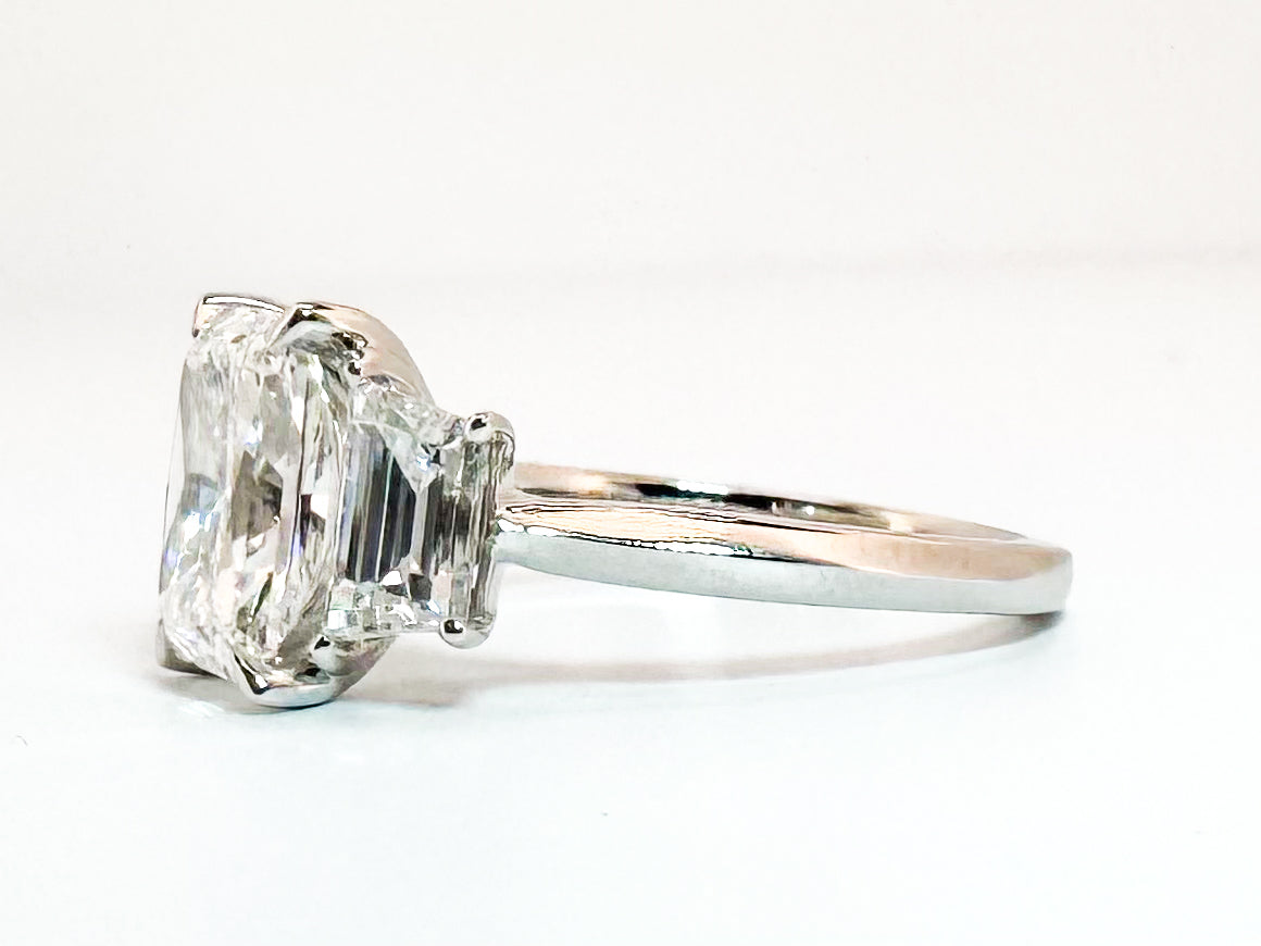 14K white gold 2.52 center radiant cut lab diamond set with 1.35 carat lab grown step shield side diamonds.