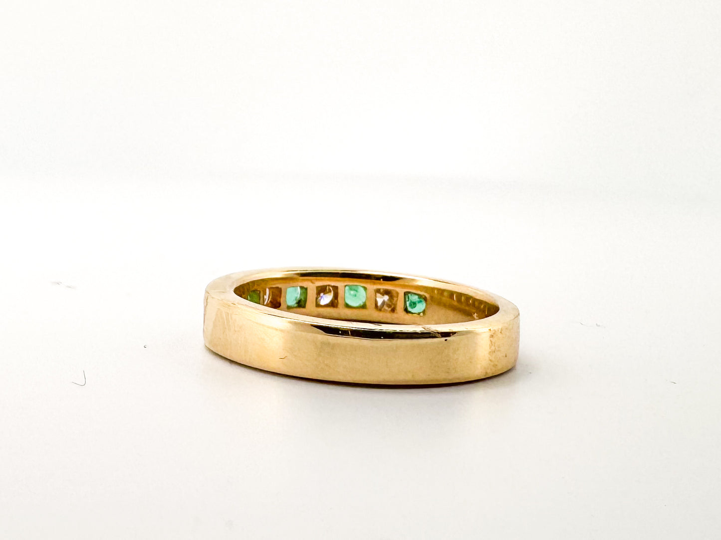 14k, Yellow gold, natural emerald and diamond channel set band.