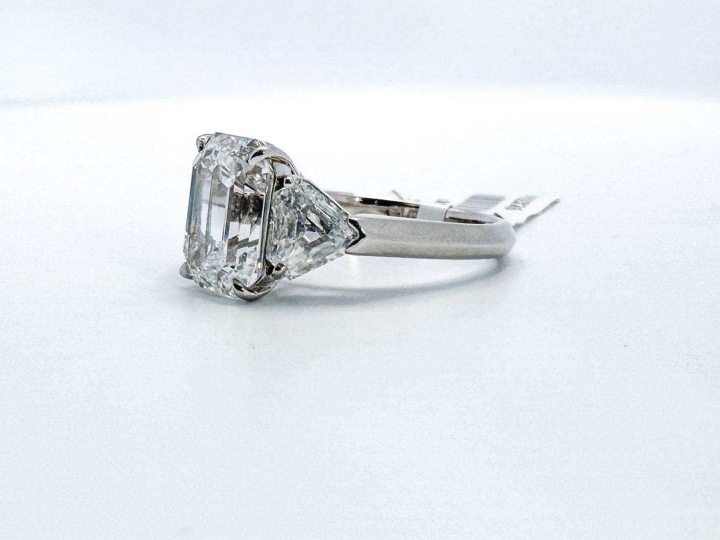 Platinum 3.18 carat natural emerald cut diamond set with 1.04 carat sheild cut side diamonds. VS2 D GIA