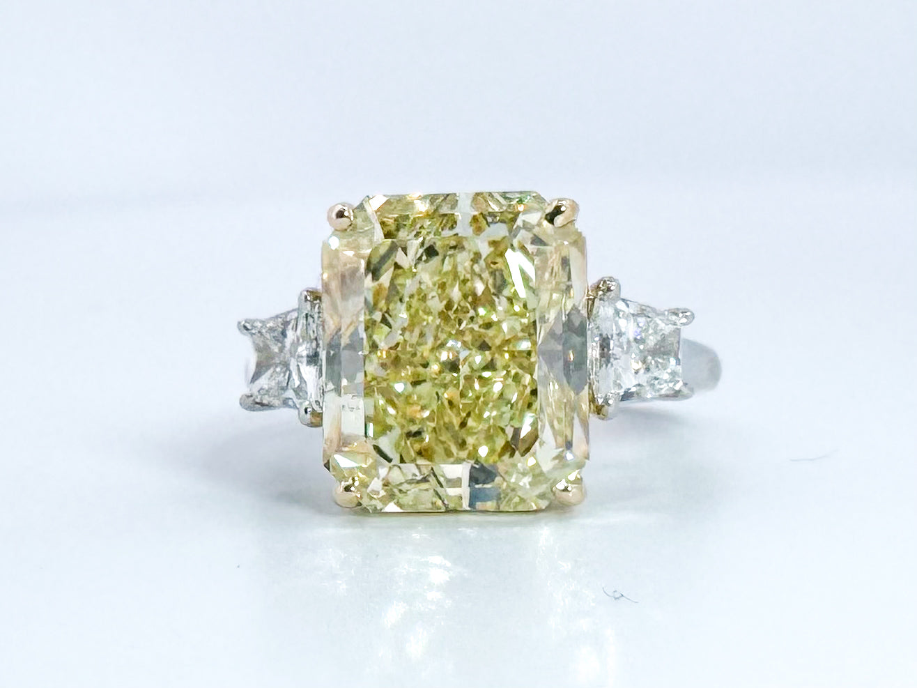 6.07 Natural Fancy light yellow, VS1 , Set in Platinum and 18k with 1.00 carat of side diamond trapezoids.