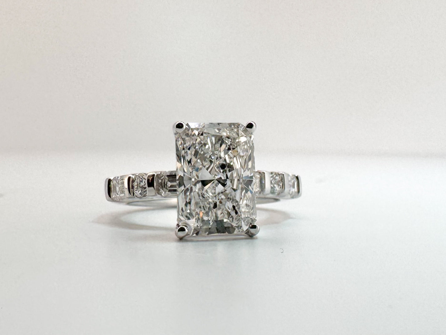 3.05 VS1 E, lab grown radiant cut diamond, set with .87 carats of side diamonds. IGI certified