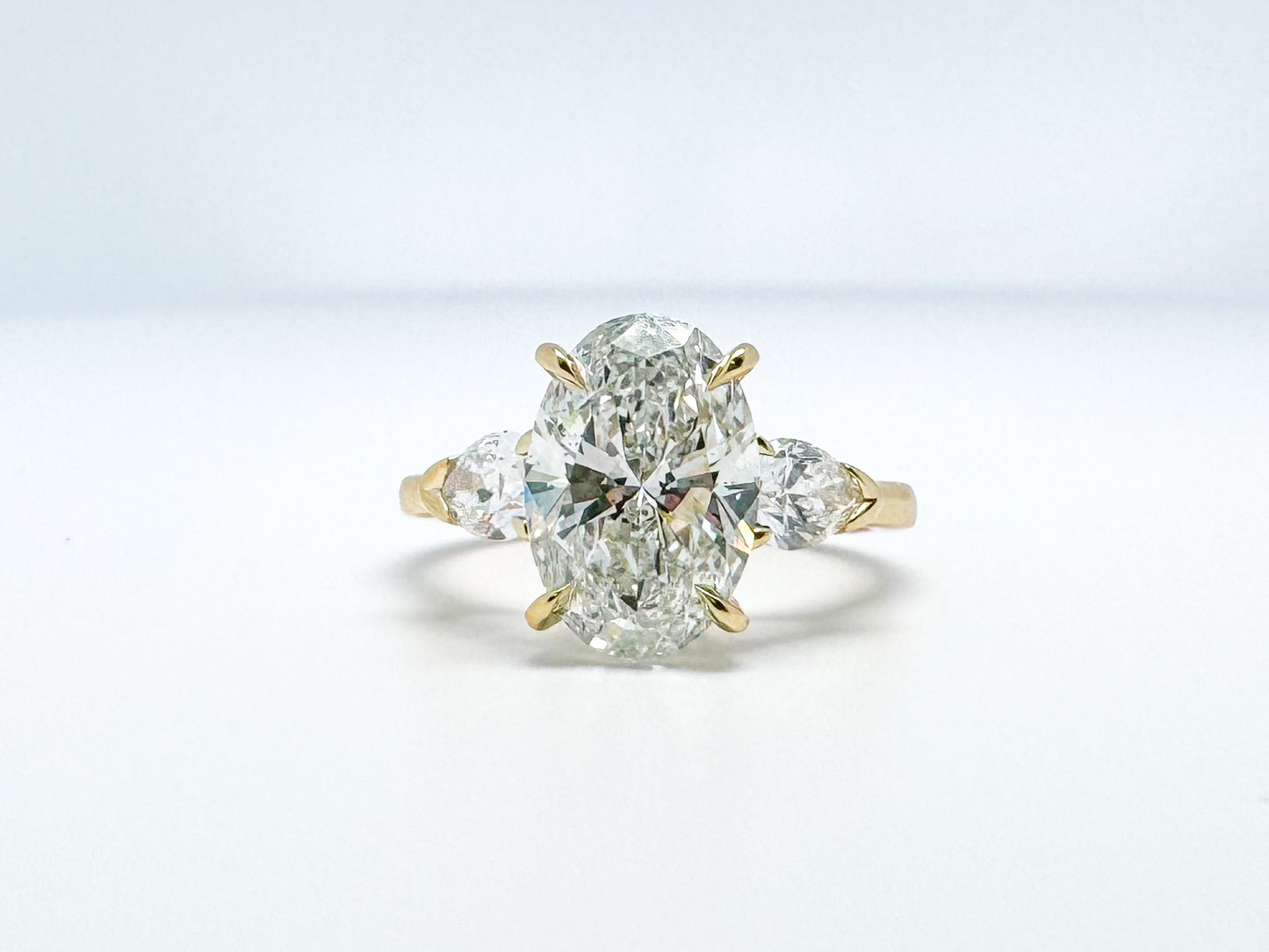 Lab grown three stone diamond ring 3.14 oval set with .62 side diamonds set in 14k yellow gold