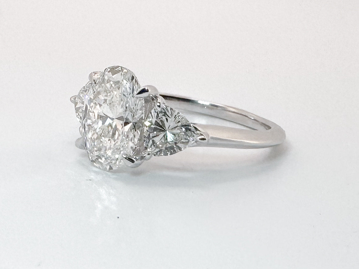 14K white gold 2.02 carat ,oval lab grown center with .98 carats of trillion cut side diamonds.