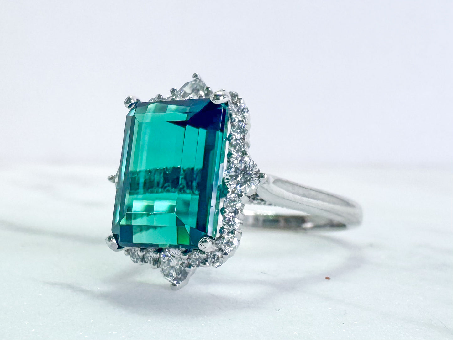 6.33 carat blue green tourmaline with .63 tw side diamond. Set in 14k white gold