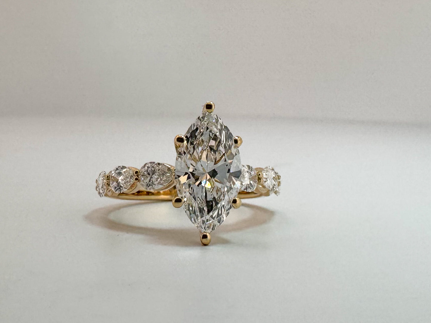 14K, Yellow gold, 2.10 carat, VS1 E Marquise cut set with .65 carats of pear shaped side dia. Lab grown IGI certified