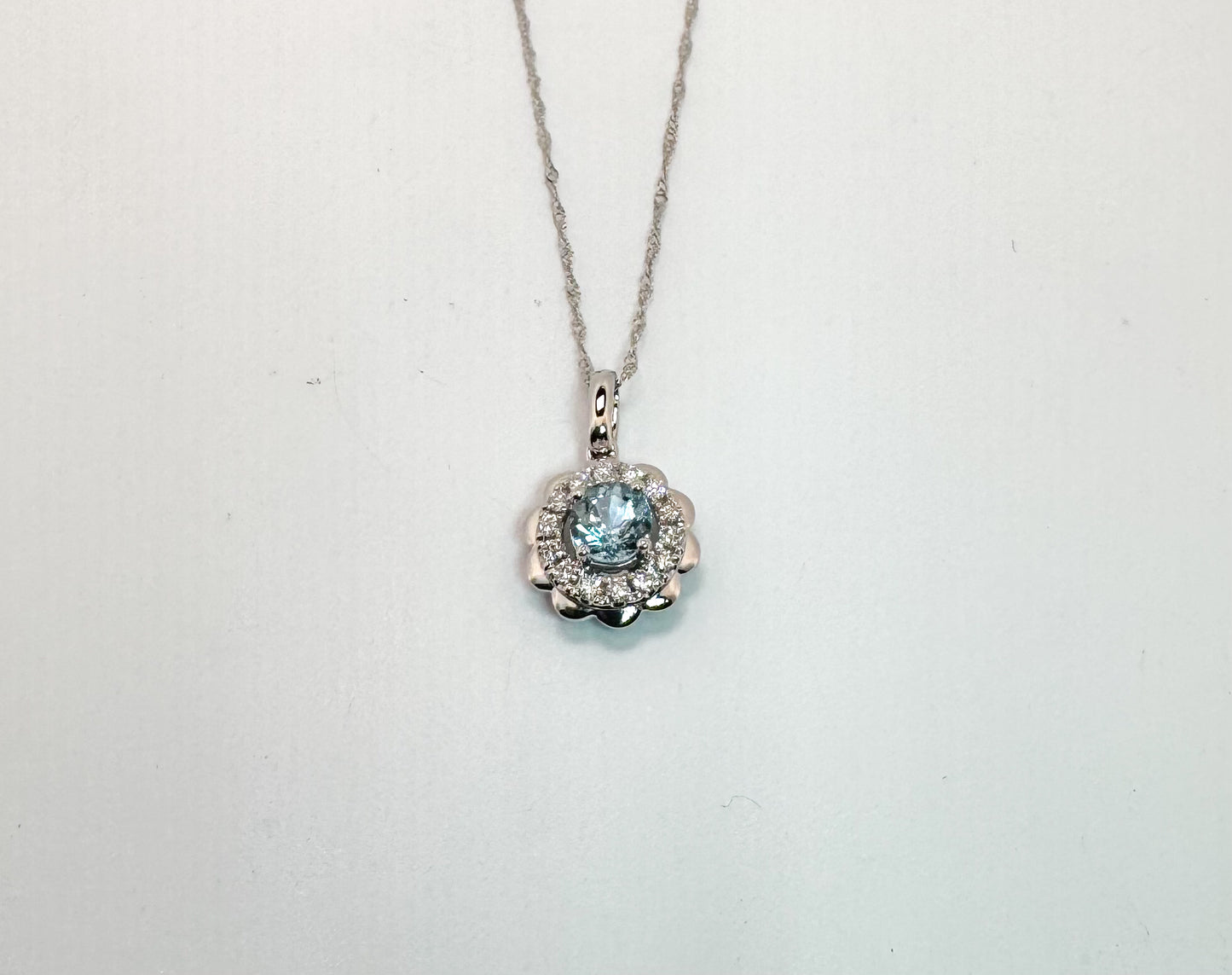 14k, White gold, .39 carat Aquamarine surrounded by .17 carats of natural diamonds. Pendant and chain.