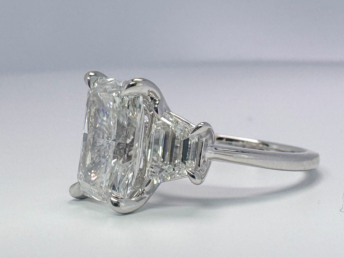 Lab grown radient cut diamond engagement ring with trapezoid sides.