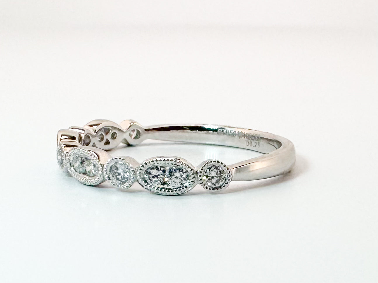 Platinum .28 diamond total weight, milgrain diamond band.