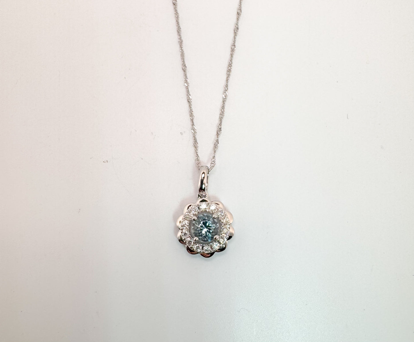 14k, White gold, .39 carat Aquamarine surrounded by .17 carats of natural diamonds. Pendant and chain.