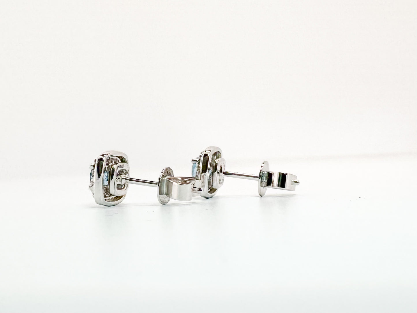 14k, white gold, .37 carats of Aquamarine surrounded by .13 carats of natural diamonds. Stud earring