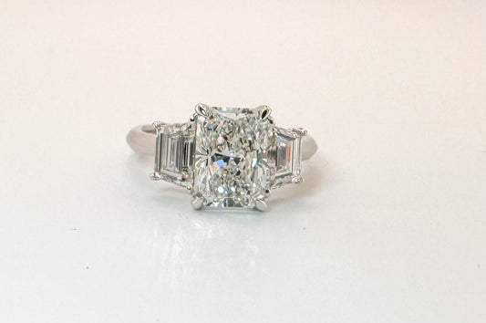 14K white gold 2.58 center radiant cut lab diamond set with 1.29 carat lab grown step shield side diamonds.