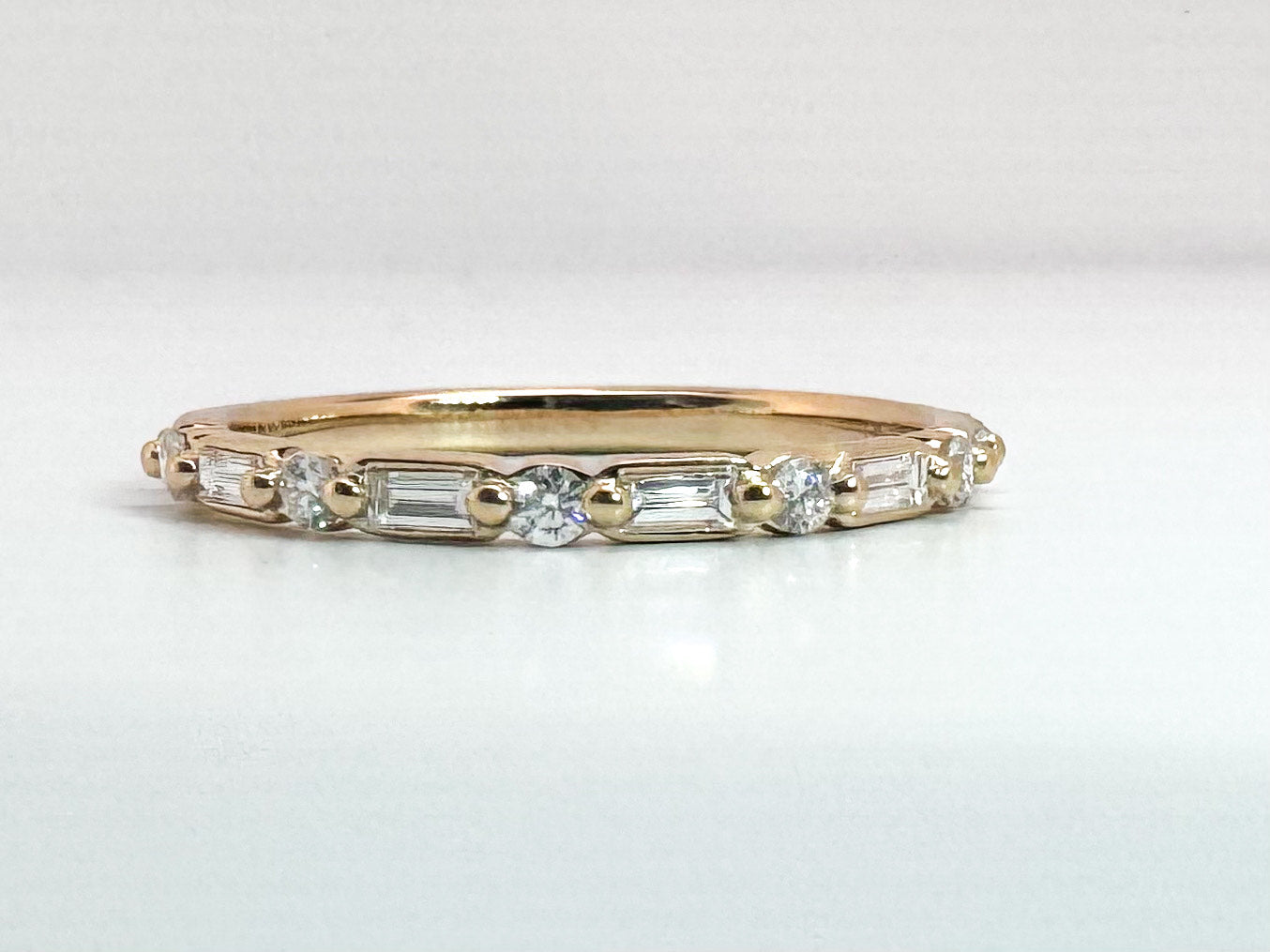 14k, yellow gold, baguette and round brilliant diamond wedding band. .25 carat total weight.