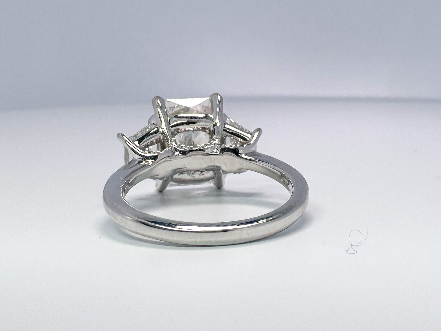 Lab grown radient cut diamond engagement ring with trapezoid sides.