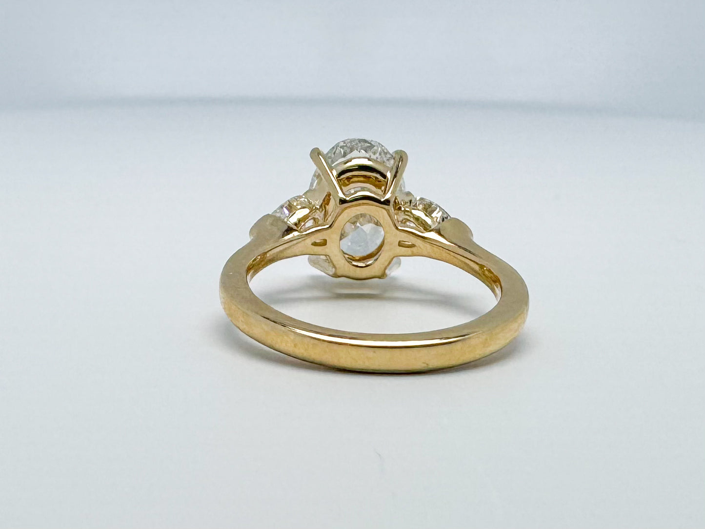 Lab grown three stone diamond ring 3.14 oval set with .62 side diamonds set in 14k yellow gold