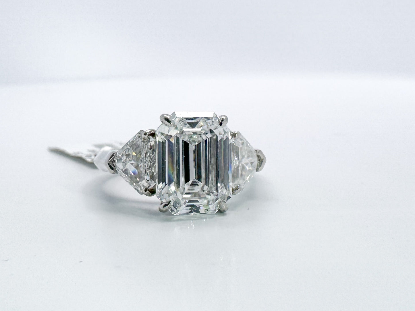 Platinum 3.18 carat natural emerald cut diamond set with 1.04 carat sheild cut side diamonds. VS2 D GIA