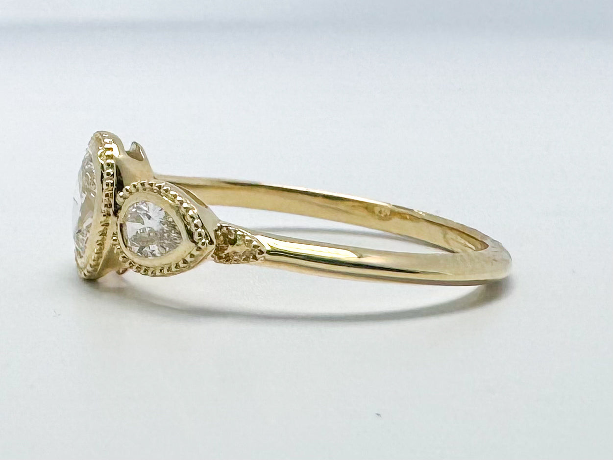 14k yellow gold three stone diamond bezel set ring. .60 carat total weight