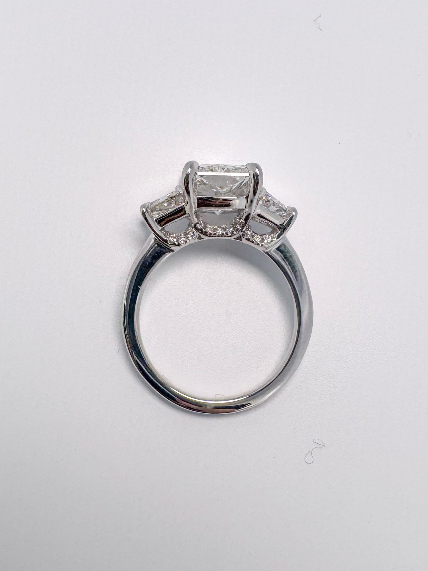 Lab grown radient cut diamond engagement ring with trapezoid sides.