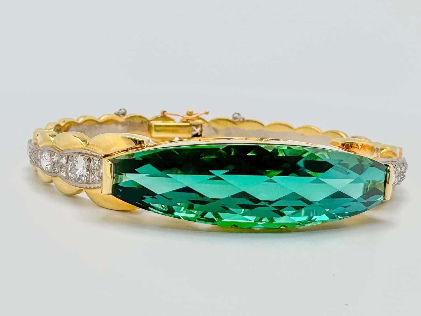 18k two tone, custom cut 26.4 carat  blue green Tourmaline with 1.44 carat total weight in side diamonds.