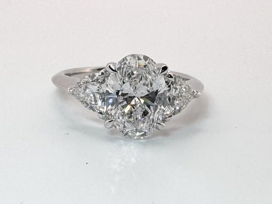 14K white gold 2.02 carat ,oval lab grown center with .98 carats of trillion cut side diamonds.