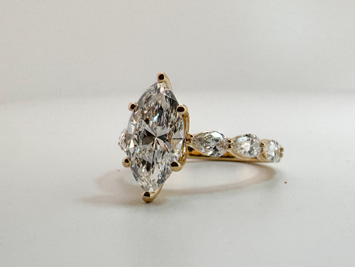 14K, Yellow gold, 2.10 carat, VS1 E Marquise cut set with .65 carats of pear shaped side dia. Lab grown IGI certified
