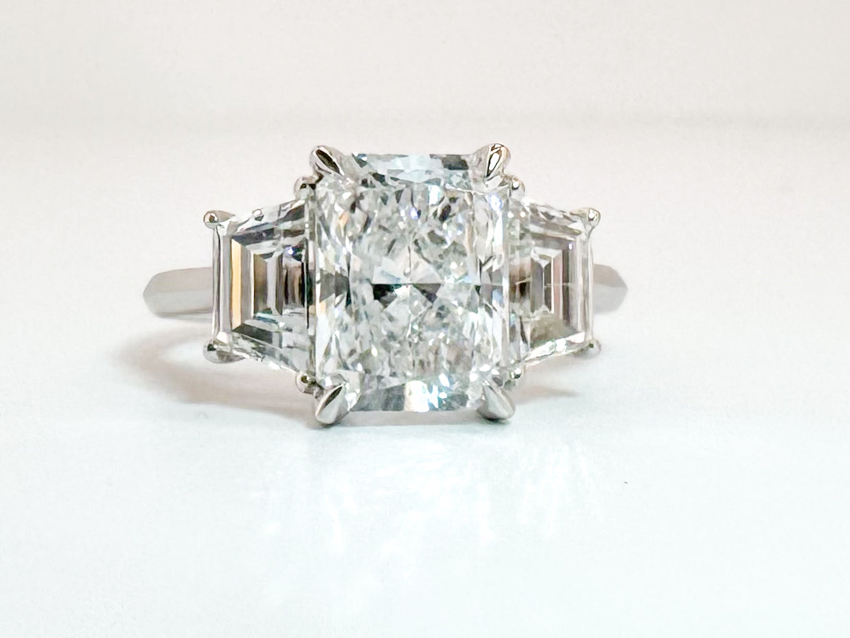 14K white gold 2.51 center radiant cut lab diamond set with 1.29 carat lab grown step shield side diamonds.