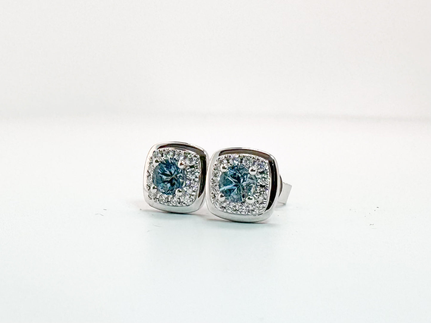 14k, white gold, .37 carats of Aquamarine surrounded by .13 carats of natural diamonds. Stud earring
